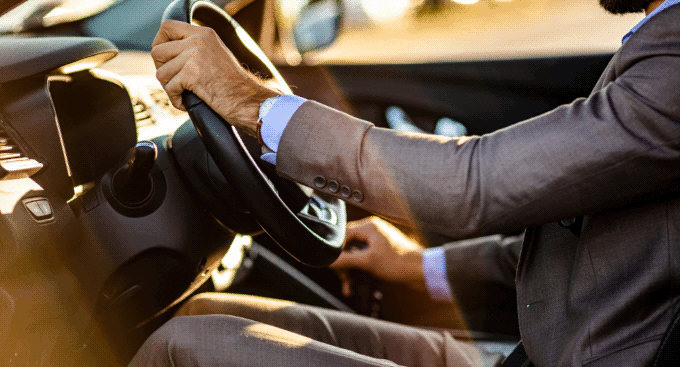 Man in a suit shifting gears in the daylight