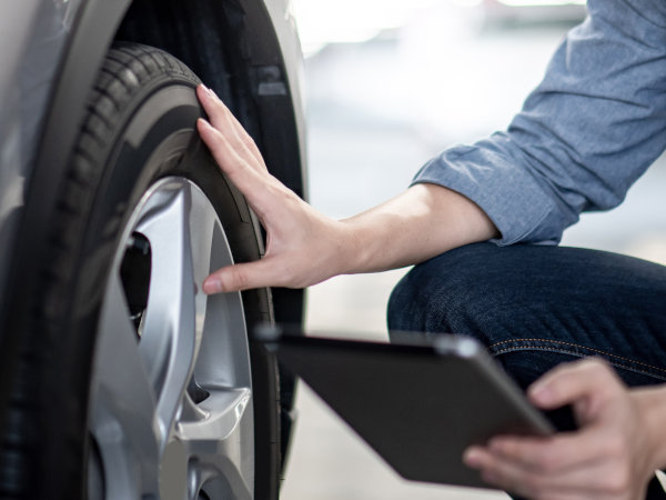 Technician looking over tires during a car maintenance check-up